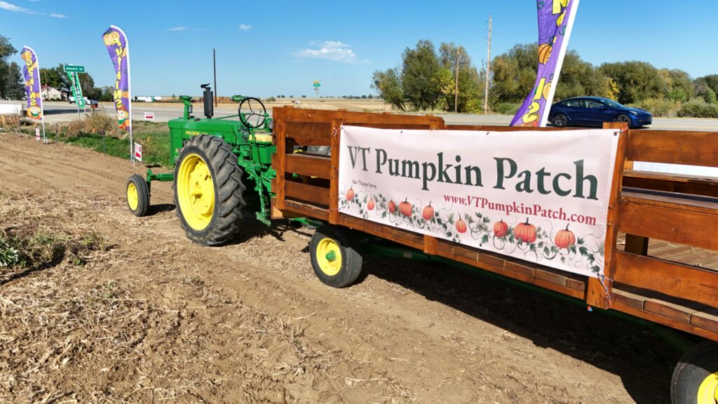 Green tractor and wooden hayride wagon at VT Pumpkin Patch